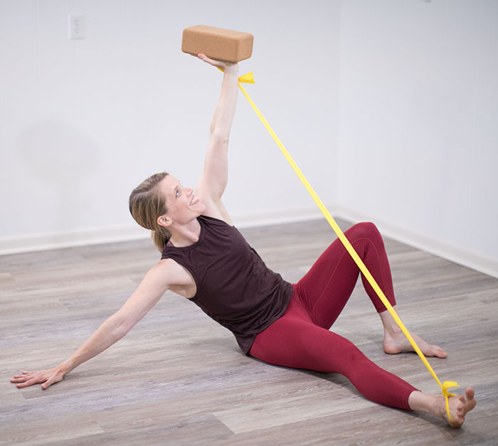 femme avec un bloc de yoga et bande élastique